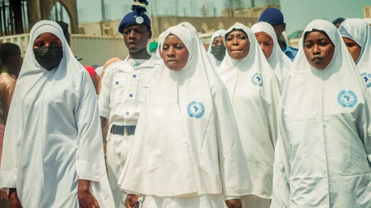 Group of women and uniformed personnel participating in a cultural parade in Zaria City, Nigeria.