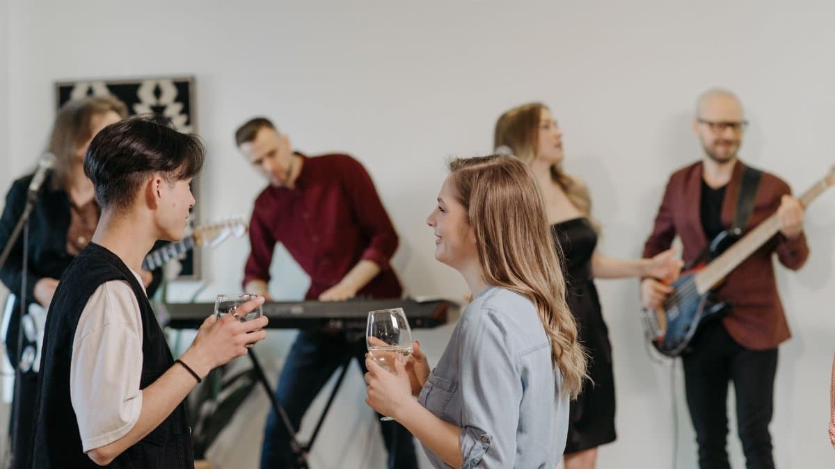 A group of friends enjoying a casual indoor home concert with live music and conversation.