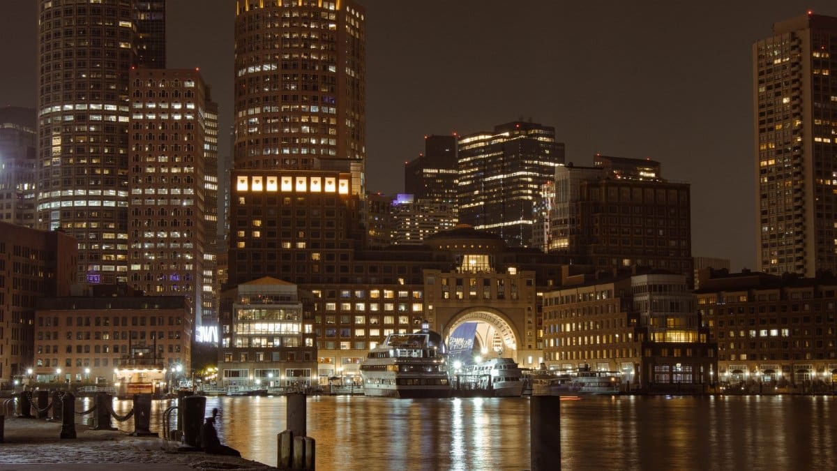 Stunning view of Boston's illuminated skyline and harbor at night showcasing iconic landmarks.