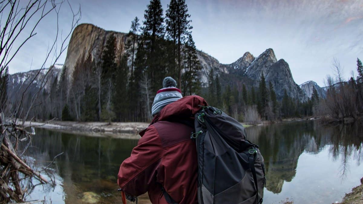 Hiker photographs scenic view of Yosemite's El Capitan during winter adventure.