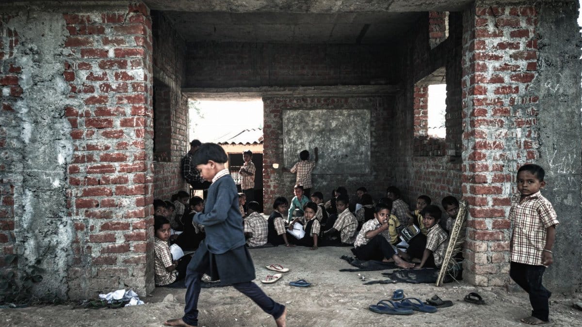 Children studying in a rustic educational setting in rural India.