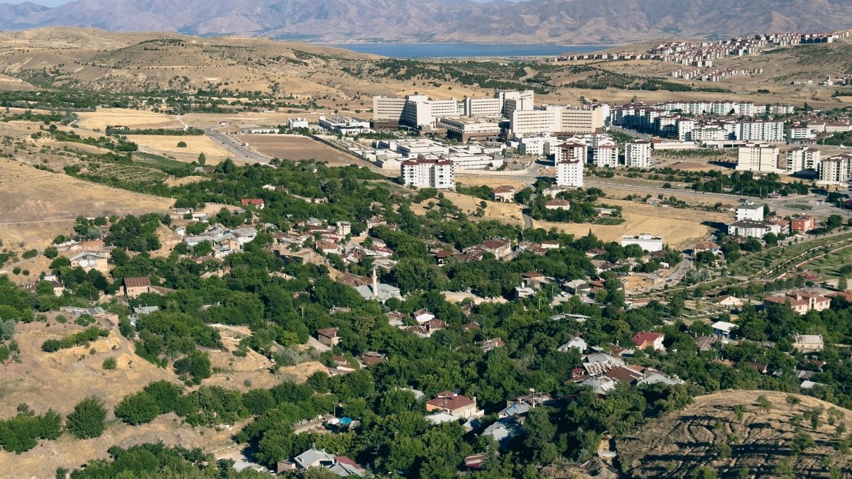 Aerial shot of Elâzığ city showcasing residential areas, hospital, and surrounding mountains.
