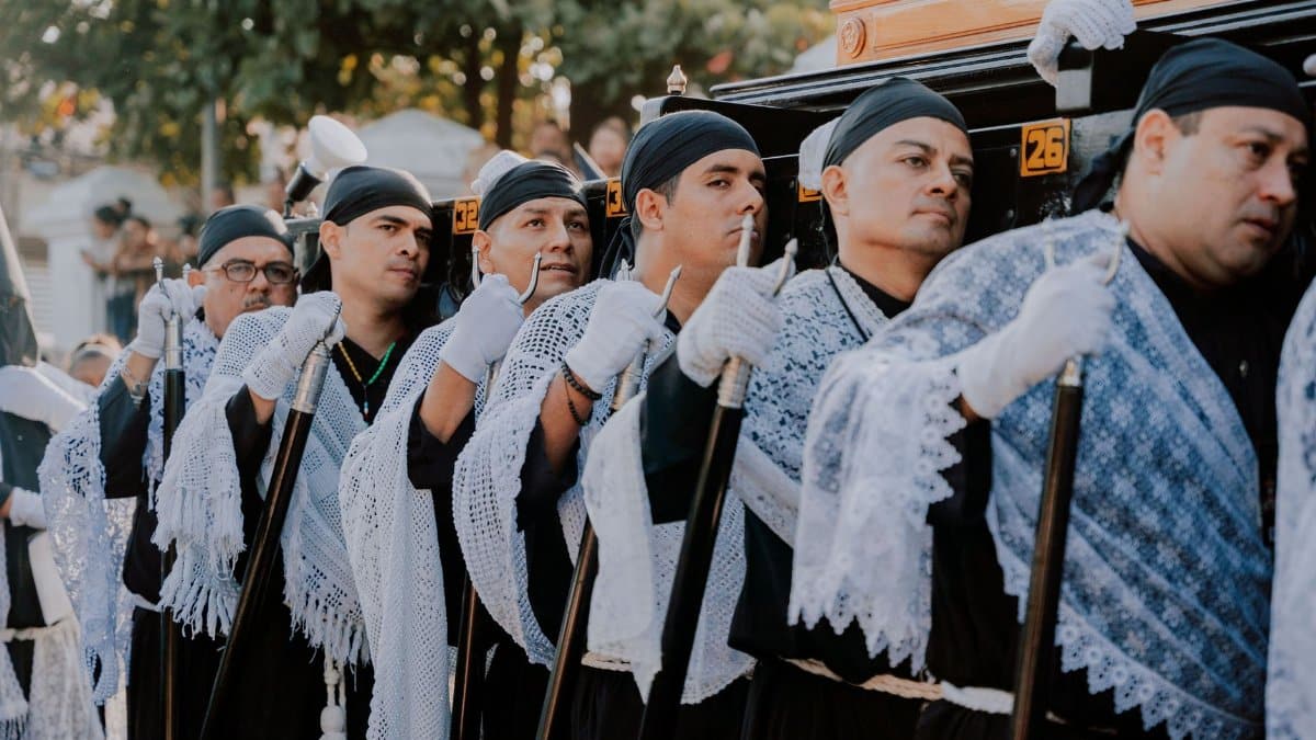 Men dressed in traditional clothing participate in a religious ceremony, showcasing cultural heritage.