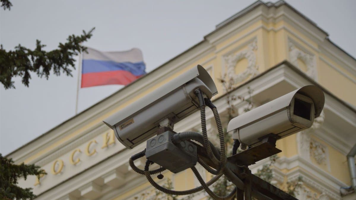 Close-up of surveillance cameras on a Russian building facade with flag.