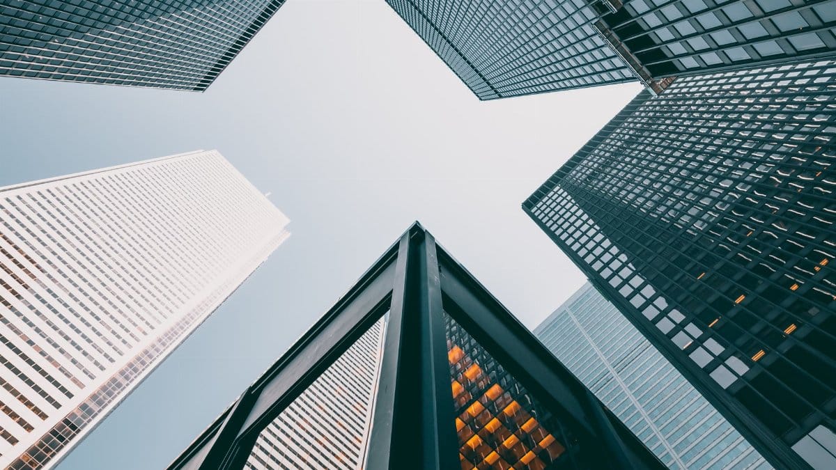 Low angle view of modern skyscrapers with glass facades against a clear sky.