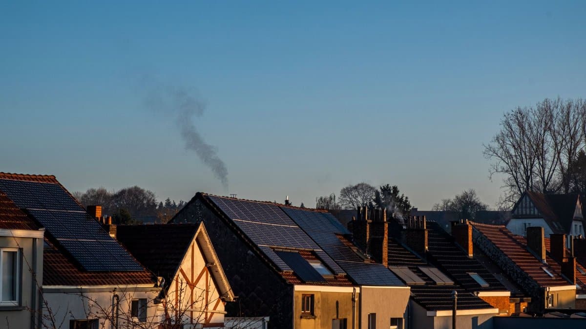 A row of houses displaying solar panels on their rooftops, reflecting sustainable energy practices.