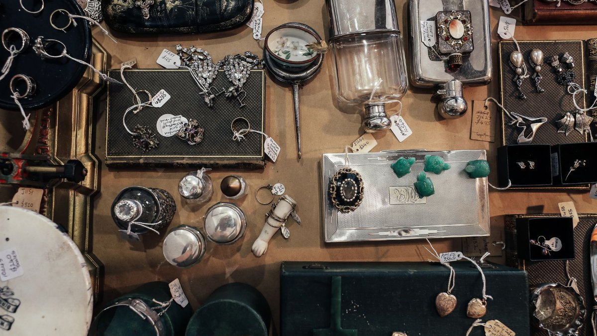 Aerial view of a vintage jewelry and antiques market display with various items for sale.