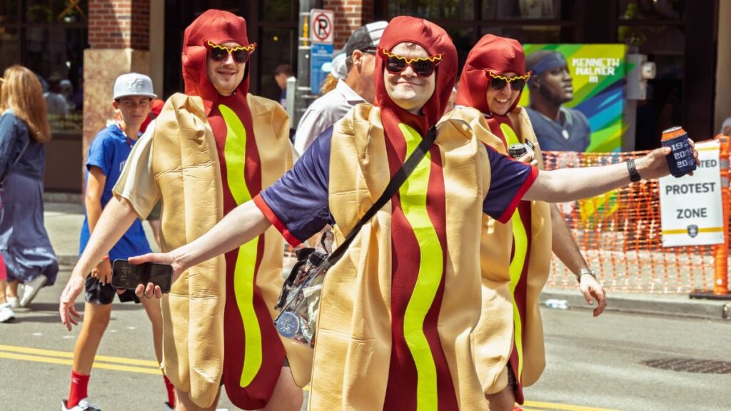 Group of adults in hot dog costumes enjoying a parade in vibrant Seattle.