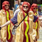 Group of adults in hot dog costumes enjoying a parade in vibrant Seattle.
