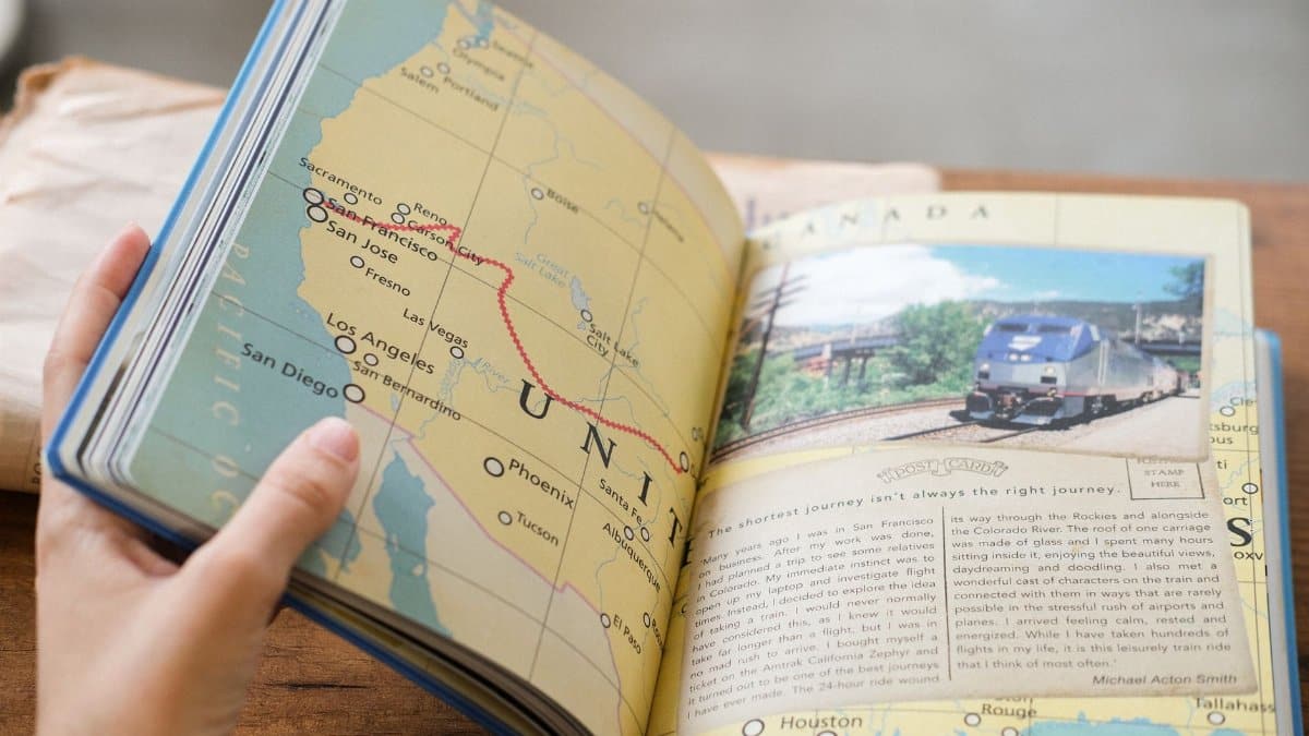 Close-up of a book showing a USA map with West Coast train routes and a train photo.