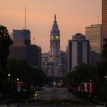 A dramatic view of Philadelphia City Hall with the skyline at twilight and street view.