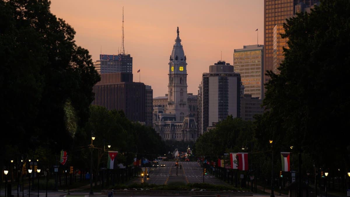 A dramatic view of Philadelphia City Hall with the skyline at twilight and street view.