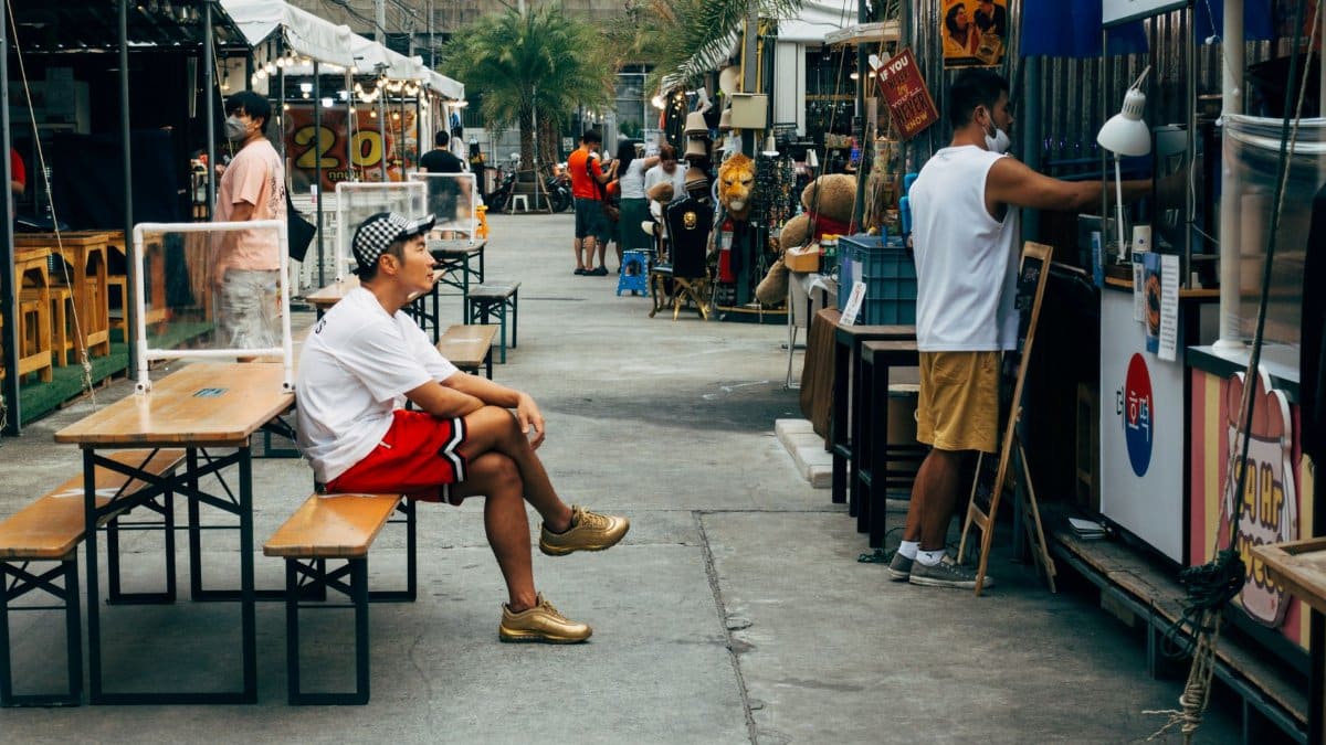 Explore the bustling atmosphere of a street market in Bangkok, showcasing local shops and culture.