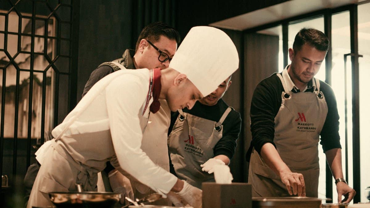 Team of chefs working together in a modern restaurant kitchen, preparing gourmet dishes with precision and skill.