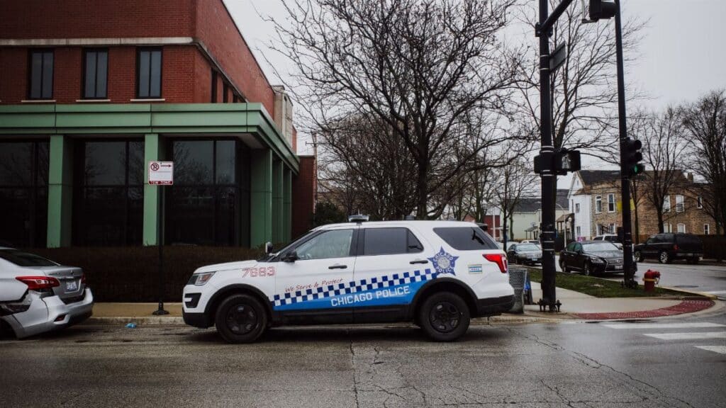 A Chicago police SUV parked on a city street near an intersection on a cloudy day.