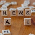 Wooden Scrabble tiles spelling 'AI' and 'NEWS' for a tech concept image.