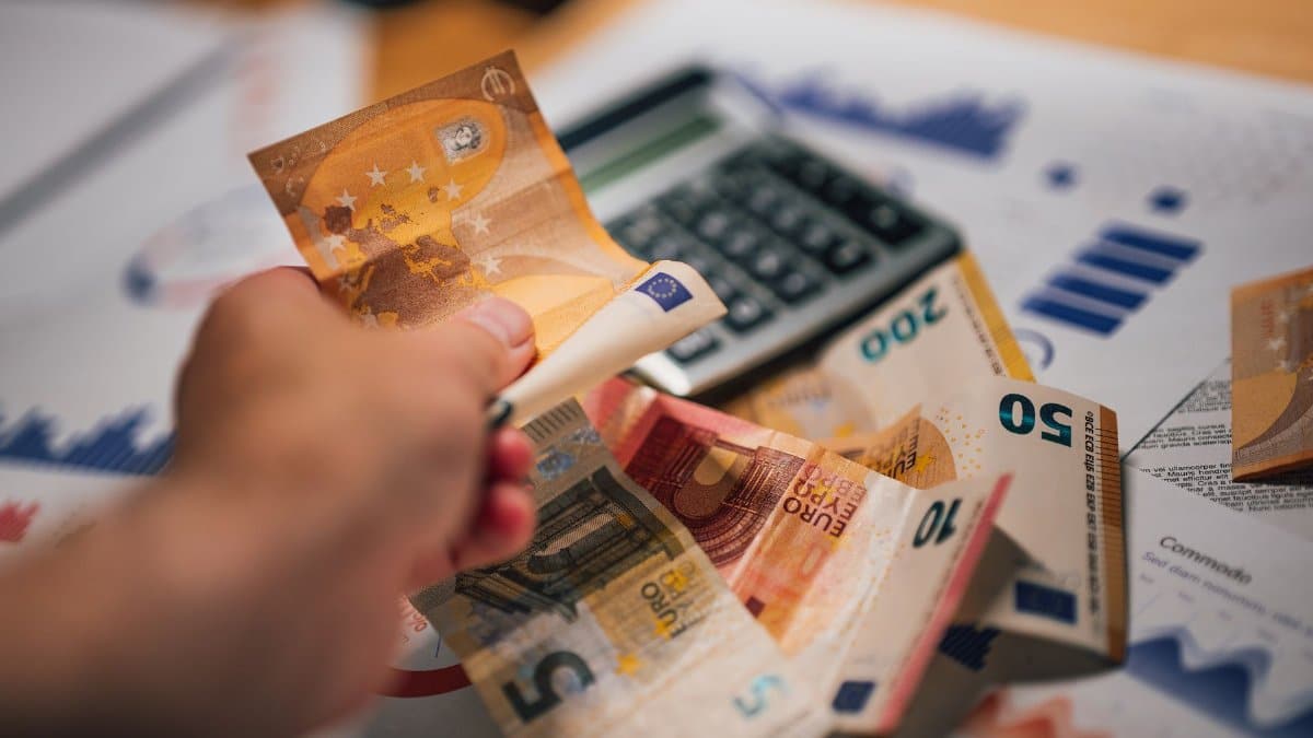 Close-up of Euro banknotes on financial documents and a calculator, depicting financial planning.