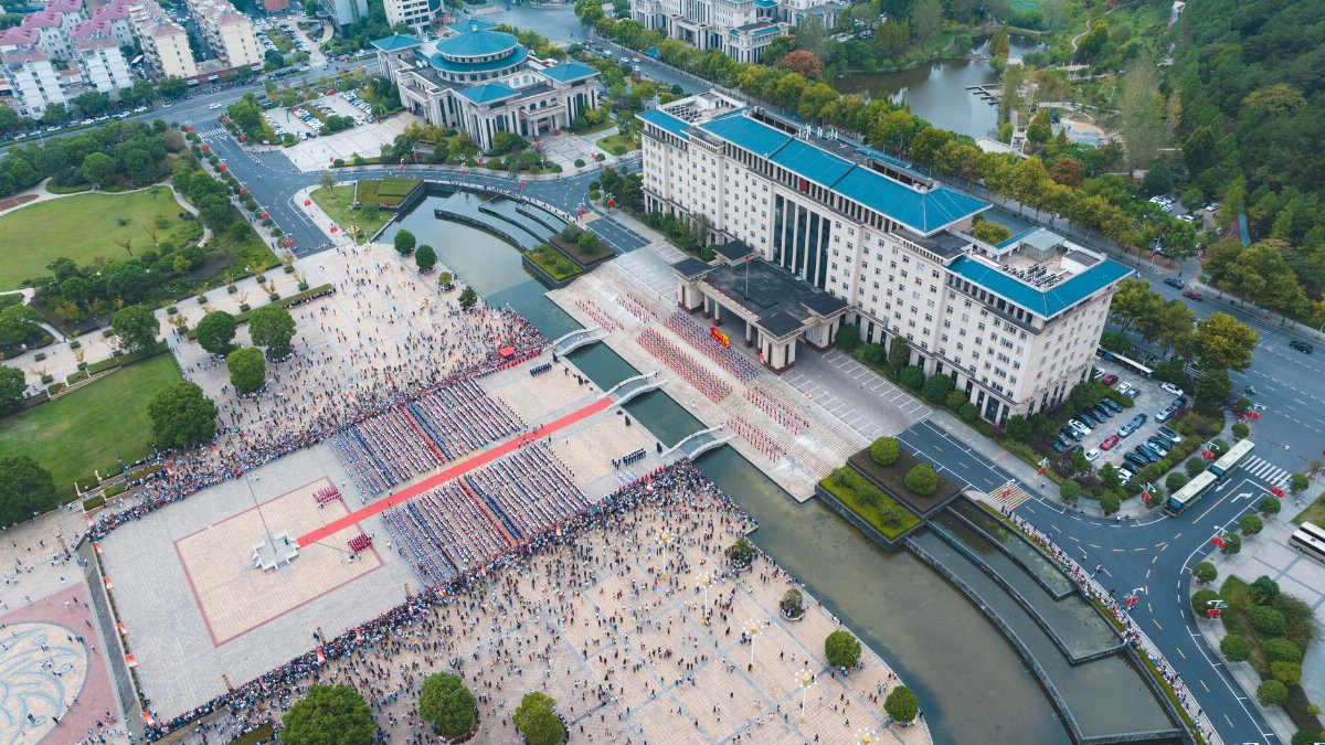 Aerial view capturing a busy city square filled with people and surrounded by buildings in China.