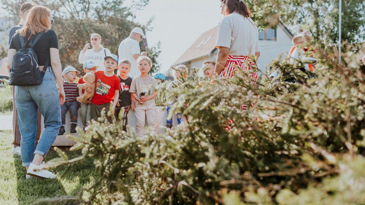 Children and adults participating in an outdoor educational activity surrounded by nature.