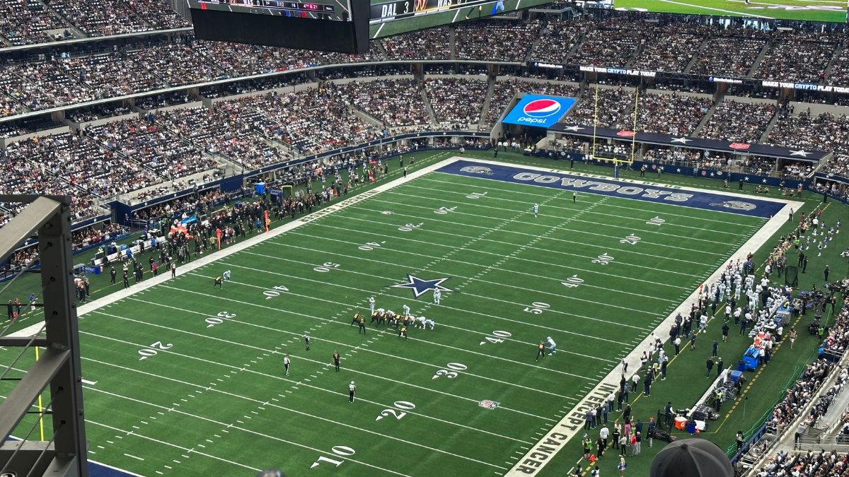 An exciting aerial shot of a football game at a packed stadium, showcasing team action on the field.