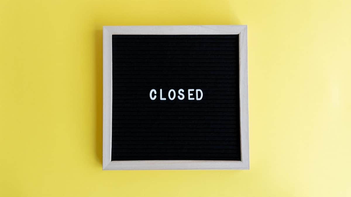 Black letter board with the word 'CLOSED' on a vibrant yellow background. Ideal for business use.