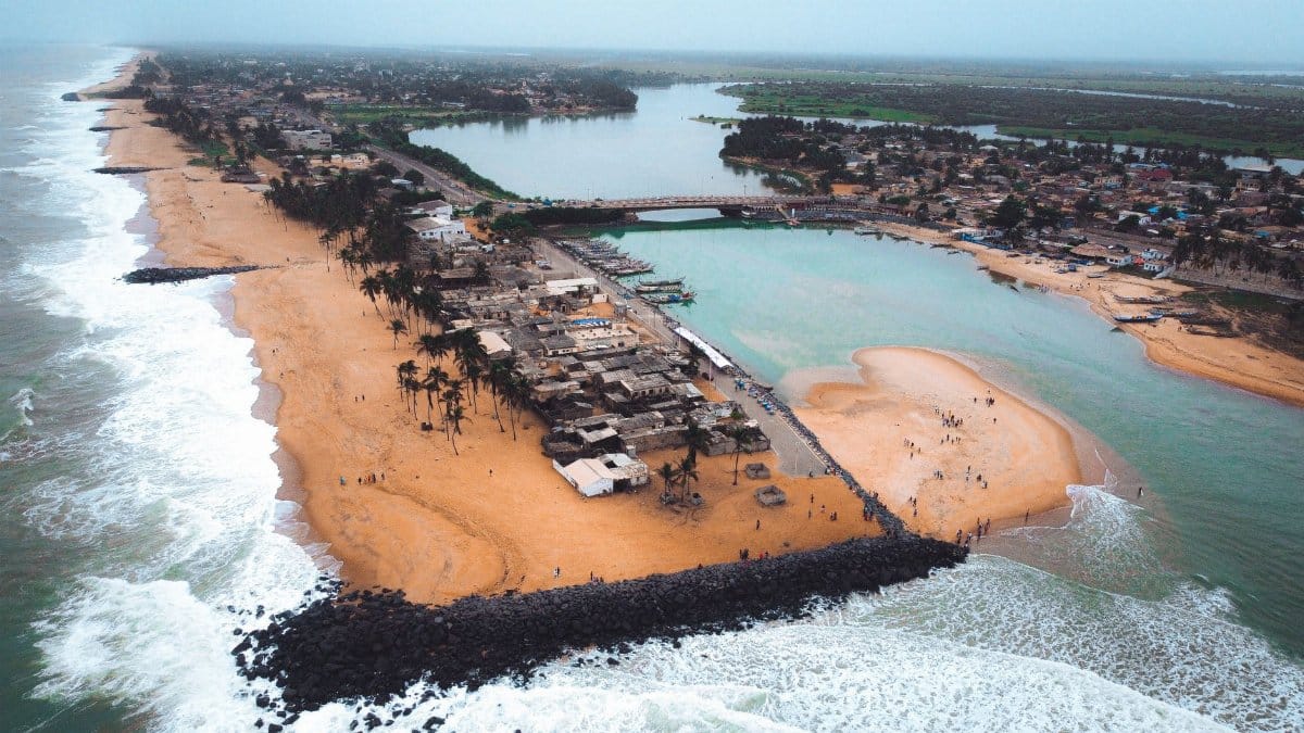 Scenic aerial view of a coastal town featuring a sandy beach and a river delta.