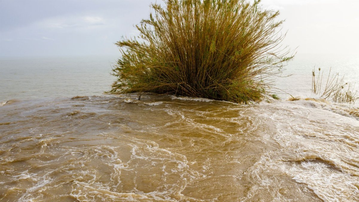 Dynamic scene with water flowing over a coastal bluff during a storm.