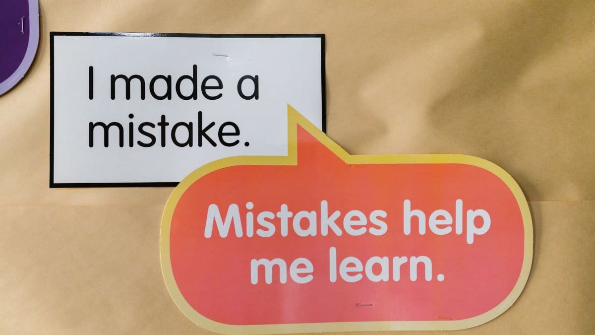 Bright square and speech bubble sign with motivational quotes about mistakes and learning.