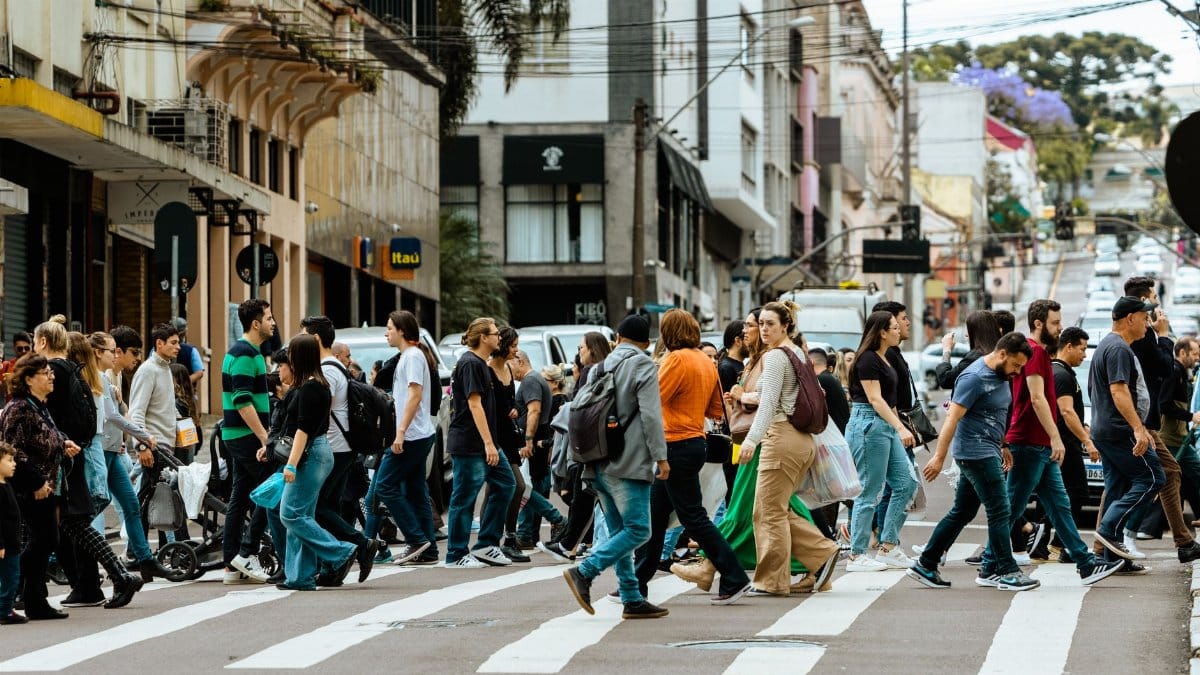 A lively crosswalk filled with people in downtown Curitiba, Brazil showcasing urban life.