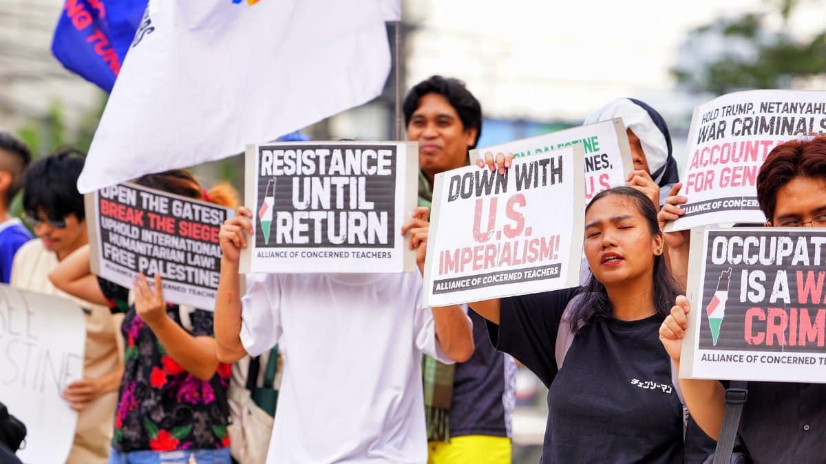 Activists in a political protest holding signs for various causes and messages.