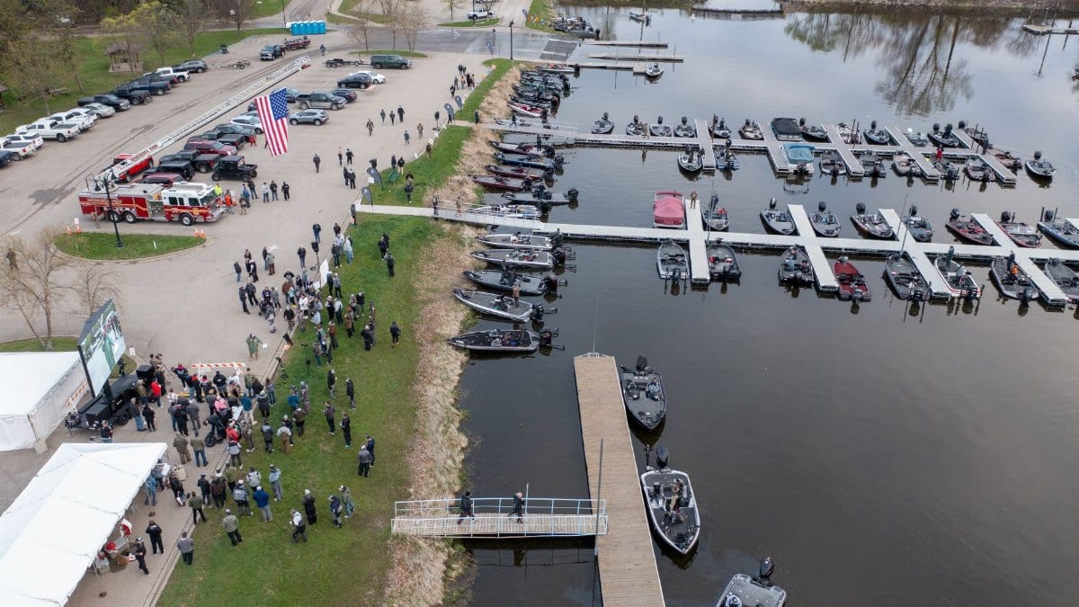 Aerial shot of a marina with boats and a crowd gathering at Wabasha, Minnesota. Includes American flag and parking.