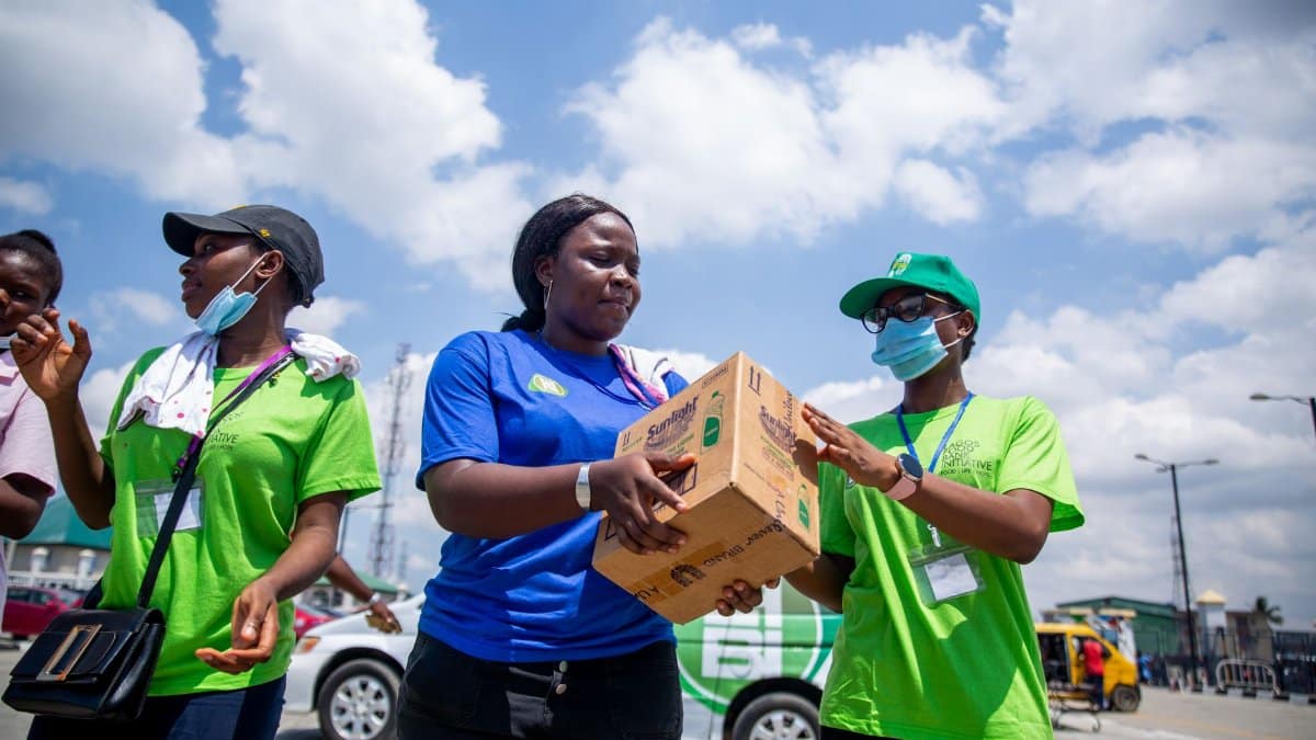 Volunteers work together in an outdoor setting, distributing donation boxes to support their community.