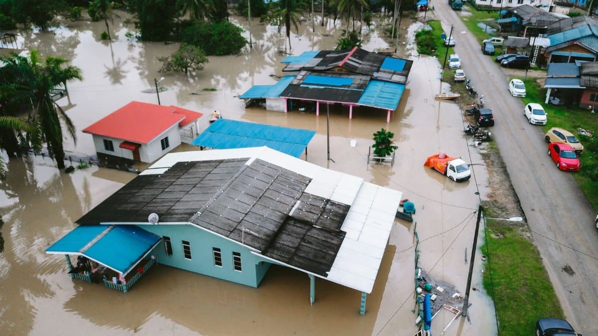 Aerial view of a flooded village in Kijal, Terengganu, Malaysia, showcasing submerged houses and streets.