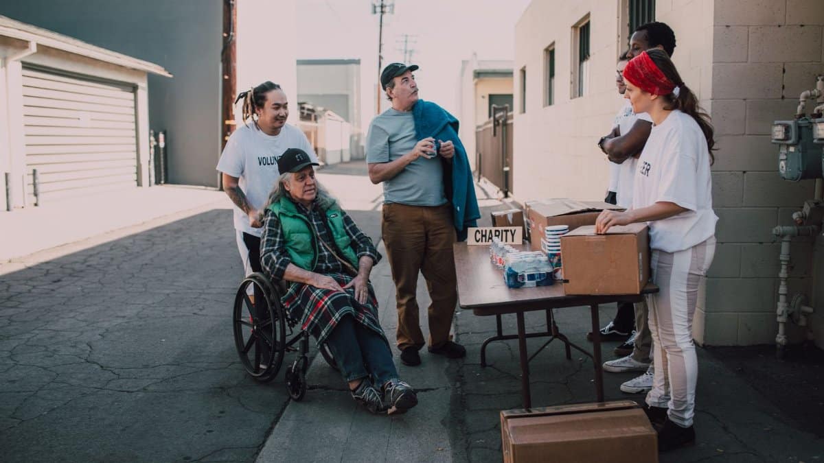 A diverse group of volunteers organizing a charity event outdoors, engaging with the local community.