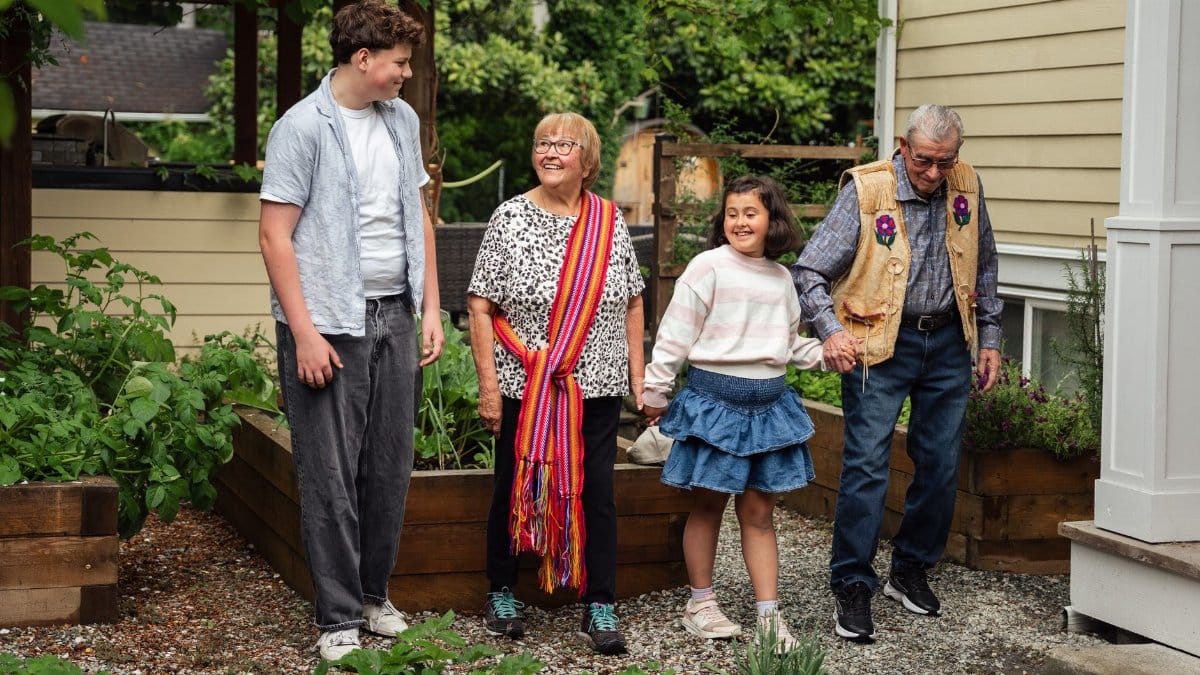 A happy multigenerational family enjoying a garden walk outdoors.