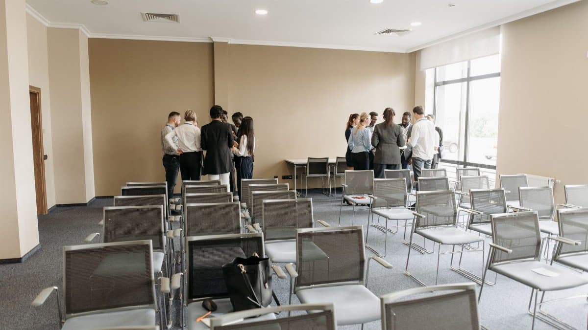 A diverse group of professionals having a discussion in an empty conference room.