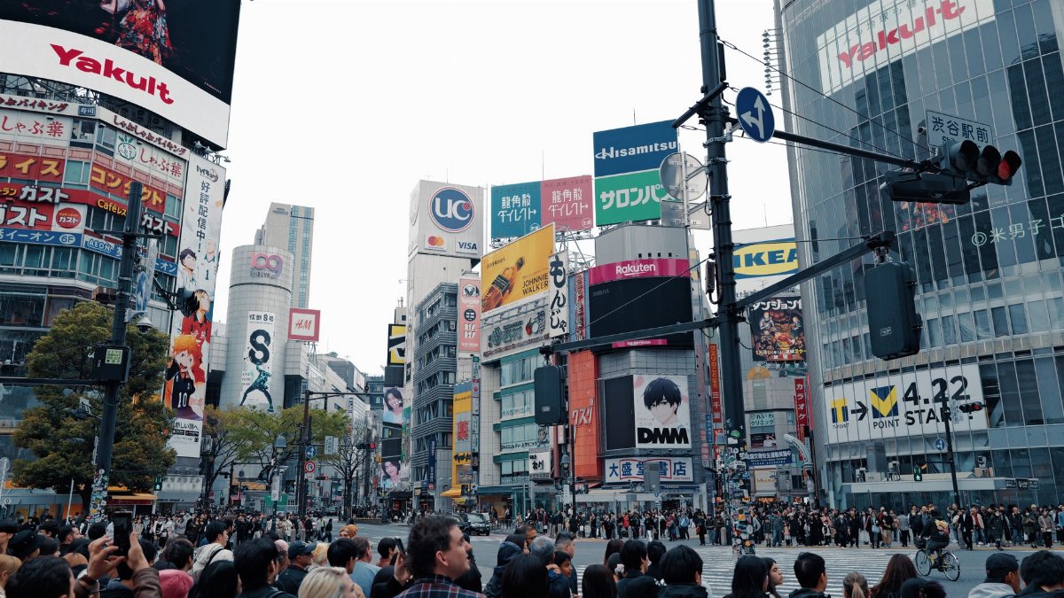 Crowds navigate the famous Shibuya Crossing, a hallmark of Tokyo's bustling urban life.