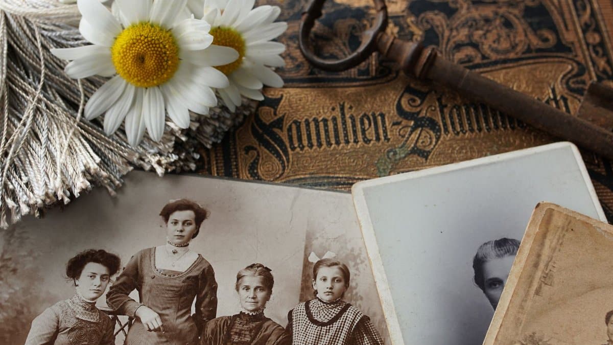 Vintage family photographs with daisies and an antique key evoke memories and nostalgia.