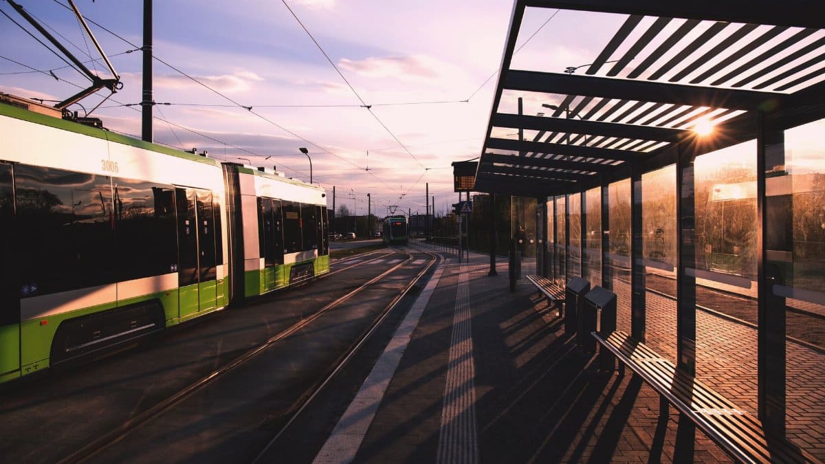 A modern urban tram station during sunset, showcasing a sleek design and vibrant colors.