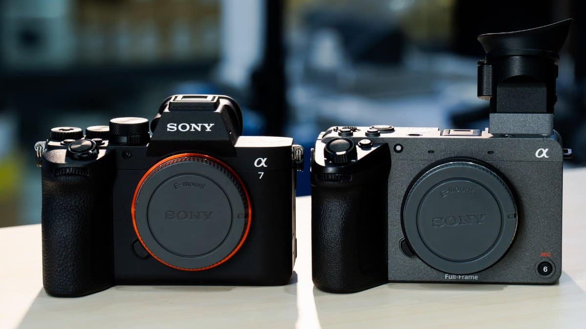 Side-by-side comparison of two modern mirrorless cameras on a table.