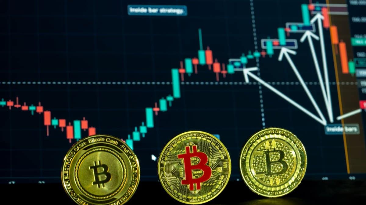 Close-up of Bitcoin coins with a financial trading graph in the background, showcasing digital currency dynamics.