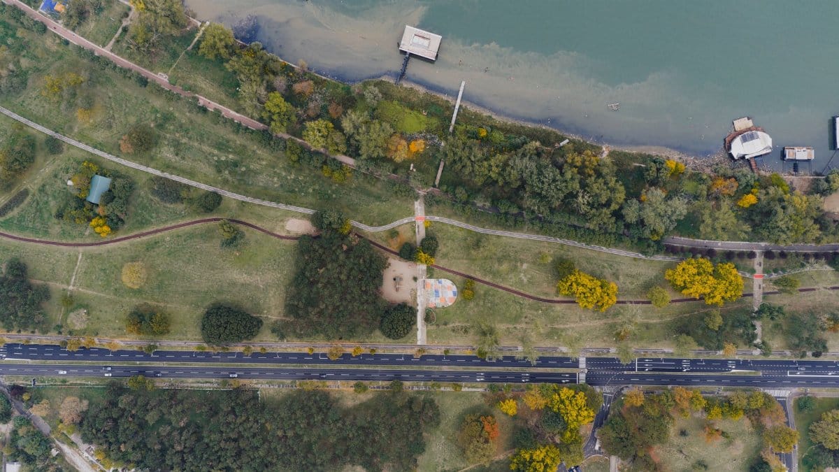 Scenic aerial shot of a park by the river in Belgrade, showcasing lush greenery and waterfront.