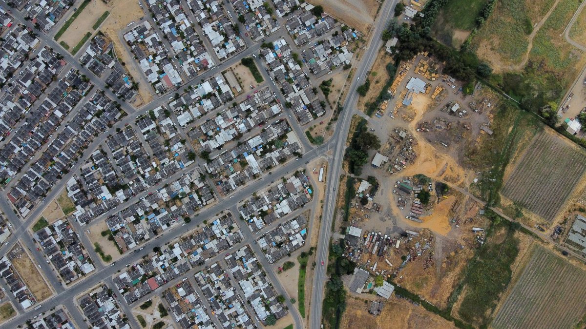 Aerial view capturing suburban neighborhood layout with roads and agriculture.