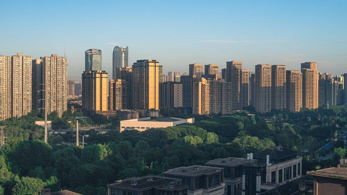 Panoramic view of a modern skyline with prominent skyscrapers and lush greenery.