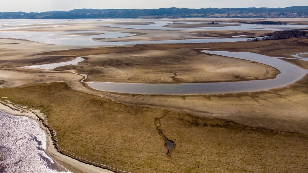 Aerial view of a vast, drying lake and riverbed, illustrating environmental change.