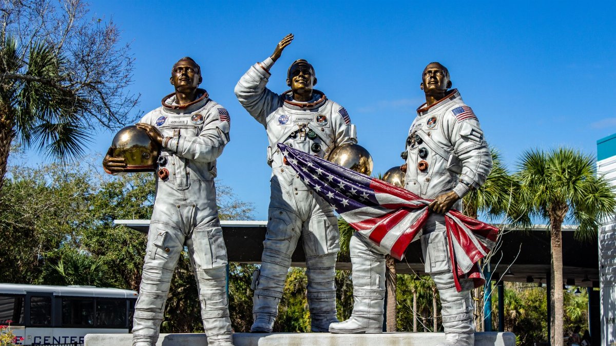 Statue of Apollo astronauts holding an American flag at Kennedy Space Center, Florida.