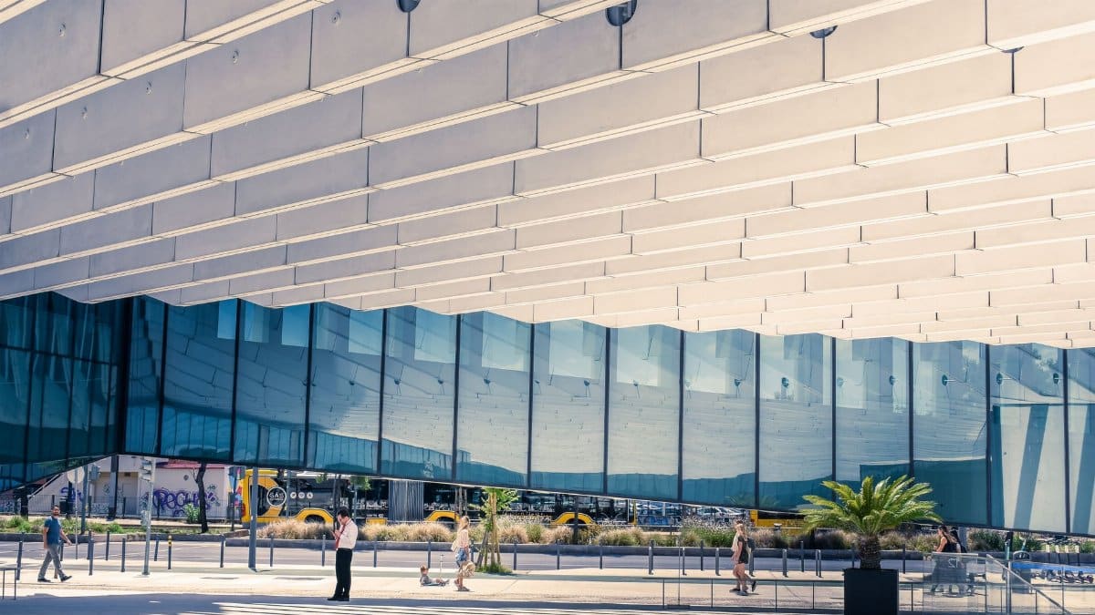 Contemporary urban architecture in Lisboa, showcasing reflections and human interaction.