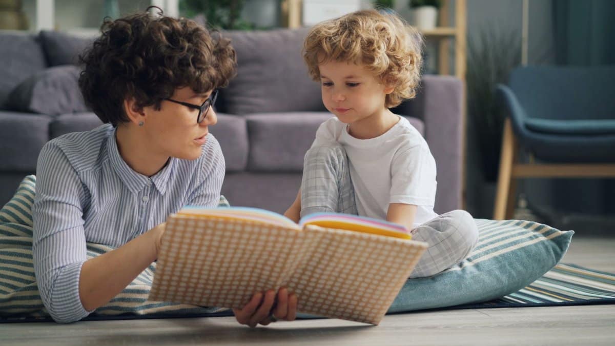 A woman and child bonding over a book in a cozy, indoor setting.