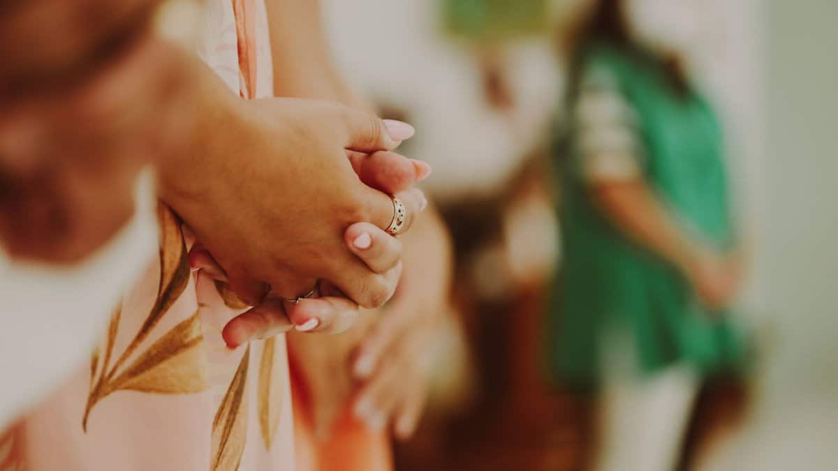 Close-up of clasped hands in a prayerful pose, symbolizing spirituality and reflection.