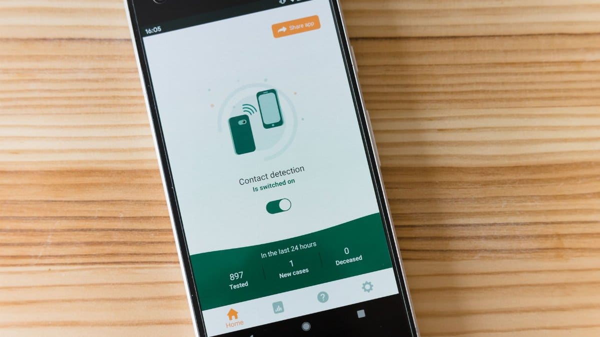 Smartphone displaying contact detection app interface on wooden table.
